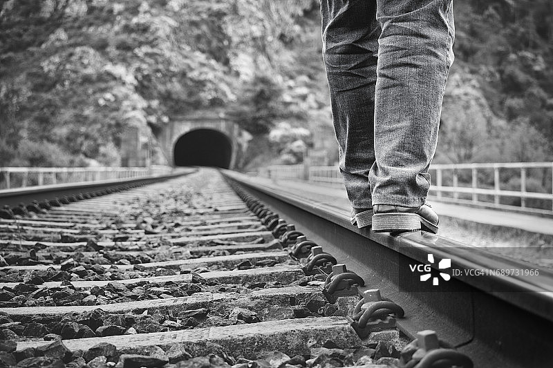 一个男人在铁轨上行走的低角度视图图片素材