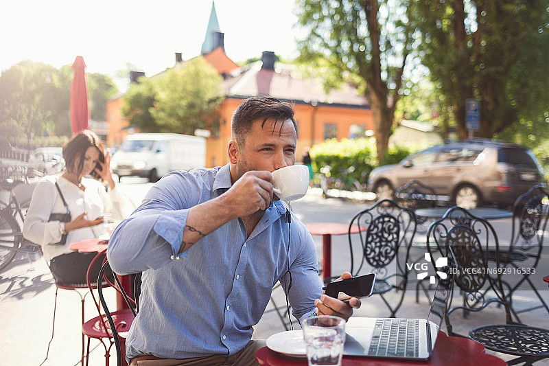 在路边咖啡馆喝咖啡的商人图片素材