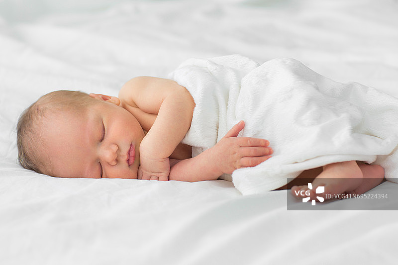 新生婴儿睡在毯子上。图片素材