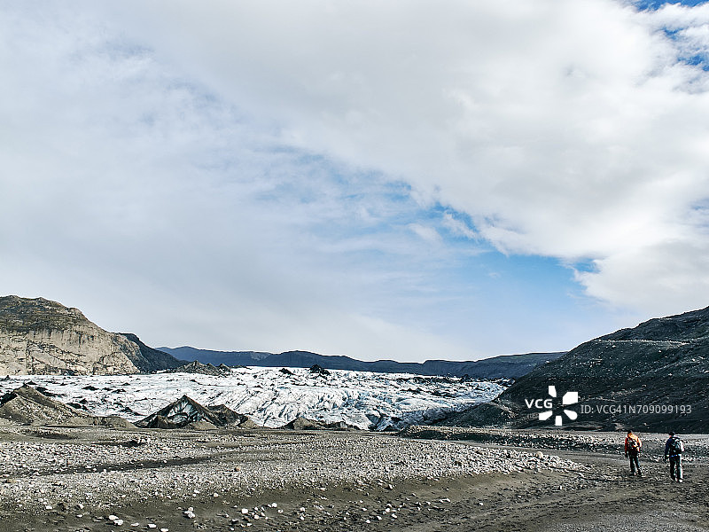 两名游客在冰岛冰川山的土路上图片素材