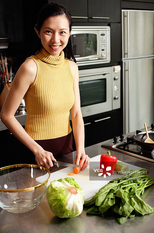 厨房里的女人，切菜，对着镜头微笑图片素材