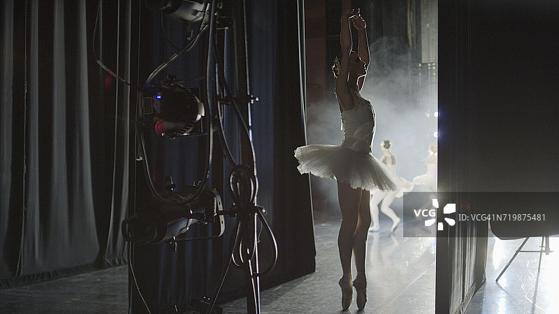 在表演期间，穿着戏服的芭蕾舞者准备在舞台上跳舞的剪影图片素材