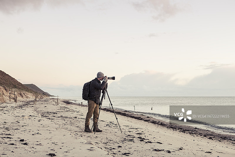 徒步者通过单反相机在海滩上拍摄的全长侧视图图片素材