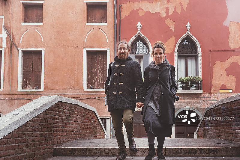 意大利威尼斯，一对情侣从运河桥上走下来图片素材