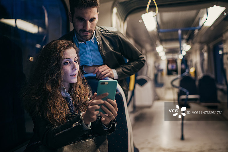 意大利佛罗伦萨，一对情侣在火车上使用手机图片素材