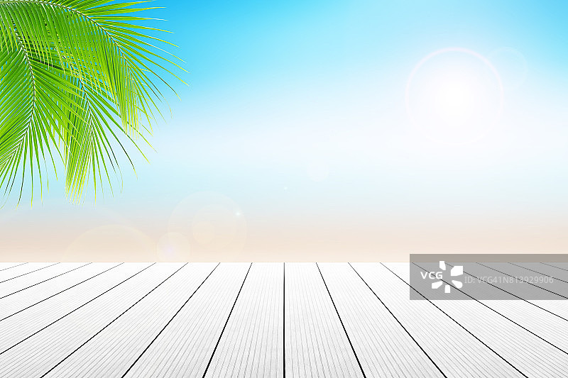 空木桌和棕榈叶与派对的海滩背景模糊。图片素材
