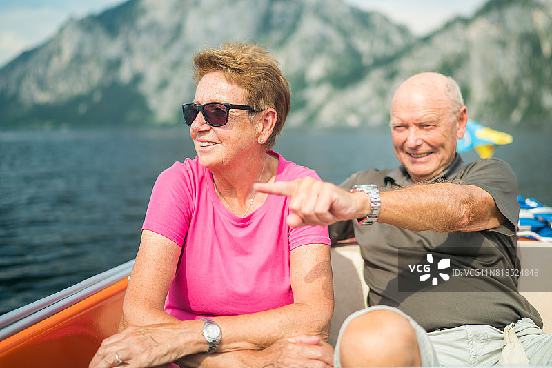社会老年人，活跃的老年夫妇喜欢在山湖上划船旅行图片素材