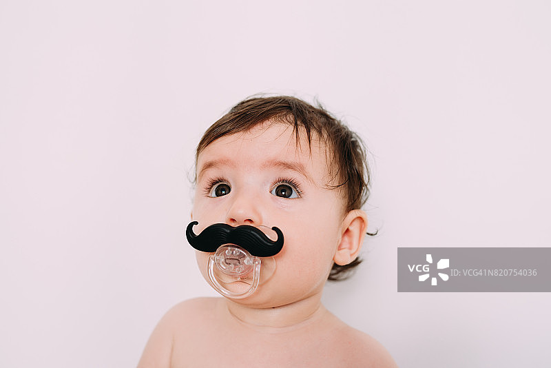 有趣的婴儿与小胡子奶嘴在白色的背景图片素材