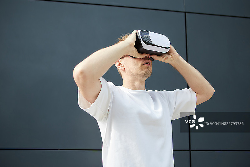 兴奋的男人戴着VR眼镜在户外图片素材