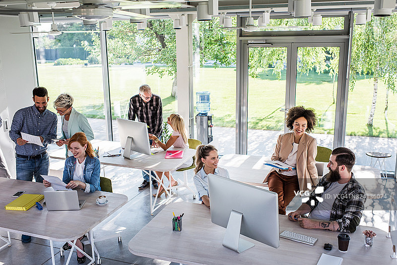 一大群忙碌的企业家在一个现代化的办公室里工作。图片素材