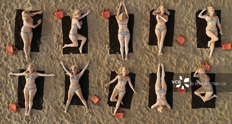 鸟瞰图的女人日光浴在海滩上在不同的位置图片素材
