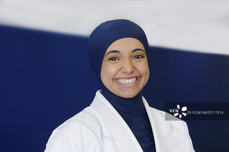穆斯林女性微笑着，戴着头巾和柔术制服图片素材