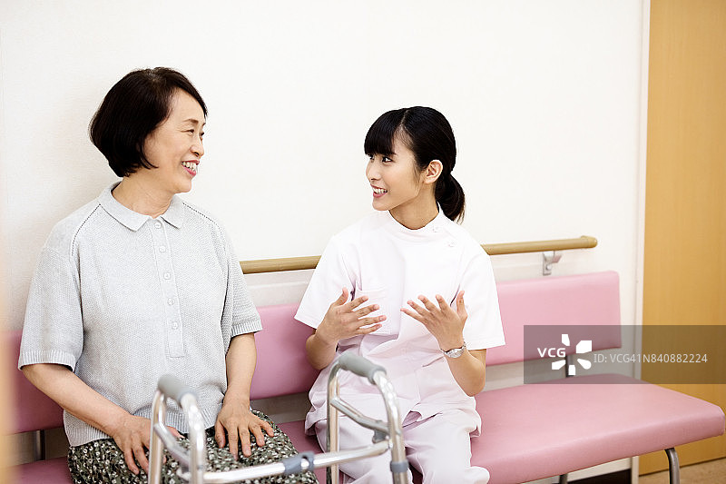 一个日本护士在医院里和一个年长的女人谈话图片素材