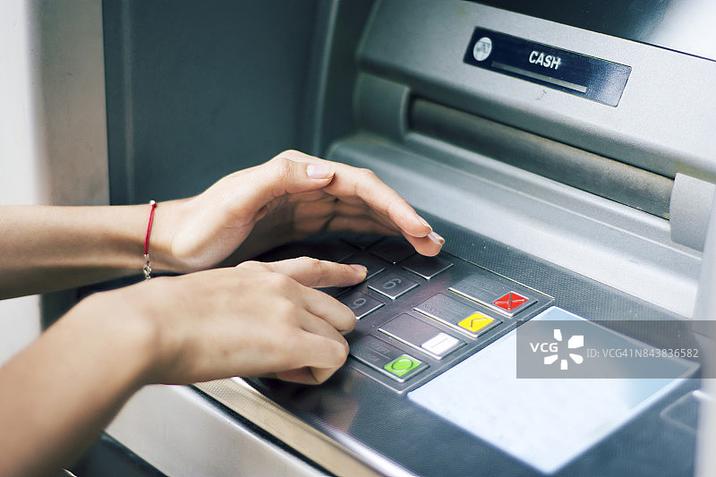 一个女人从自动取款机上取钱图片素材