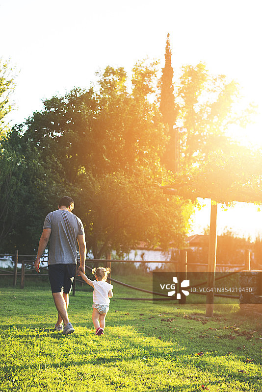 父亲和他的宝贝女儿在乡村农舍散步图片素材