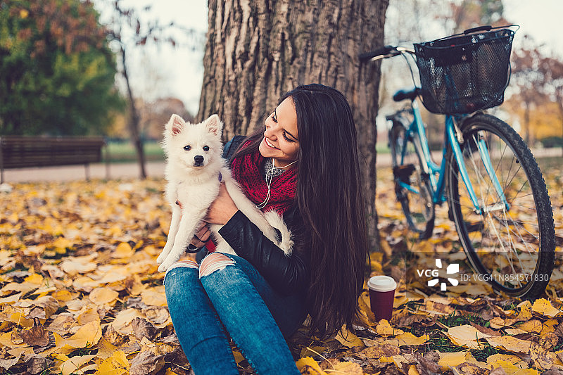 一个年轻女人在公园和她的狗玩图片素材