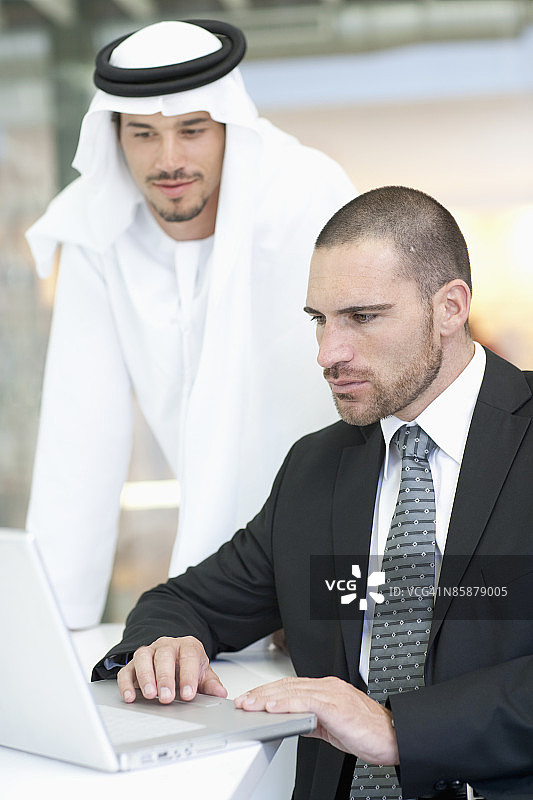 阿拉伯人和商人在办公室使用笔记本电脑。图片素材