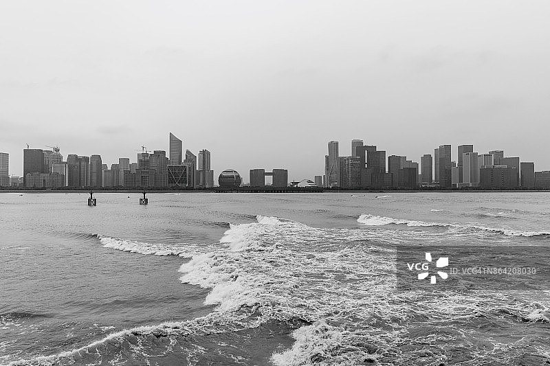钱塘江大潮与市中心天际线背景，杭州，中国图片素材