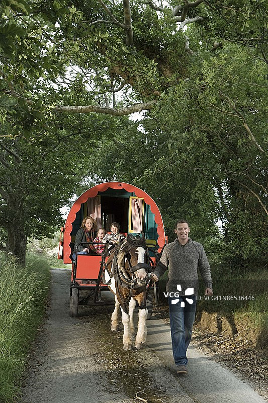 爱尔兰乡村，一家人骑着马拉的大篷车图片素材
