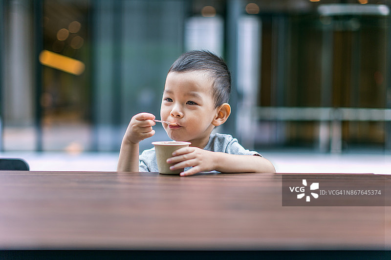 小男孩微笑着吃冰淇淋的照片图片素材