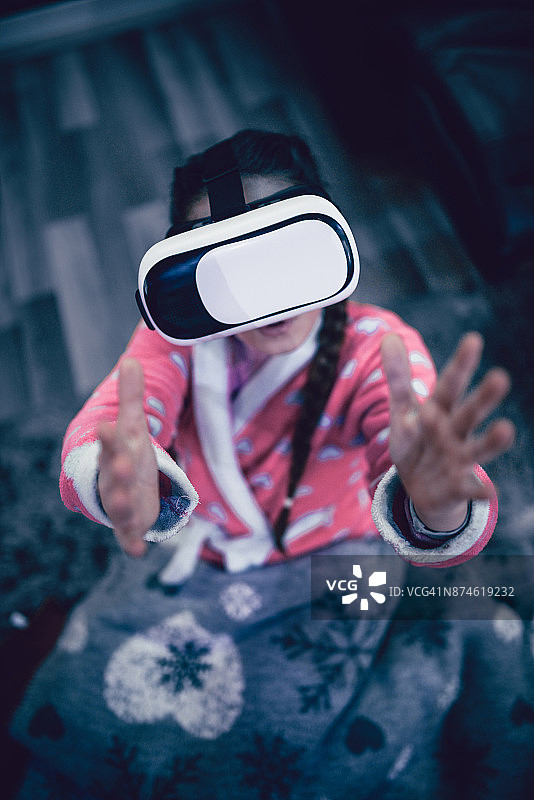 小女孩与虚拟现实模拟器和手势的乐趣图片素材
