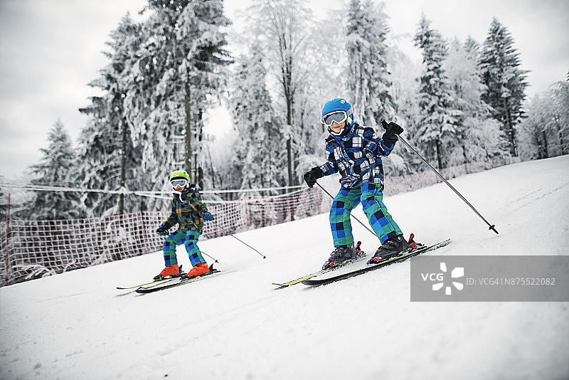 小弟弟们在一个美丽的冬日一起滑雪图片素材