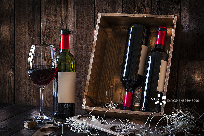 酒瓶和酒杯落在质朴的木桌上图片素材