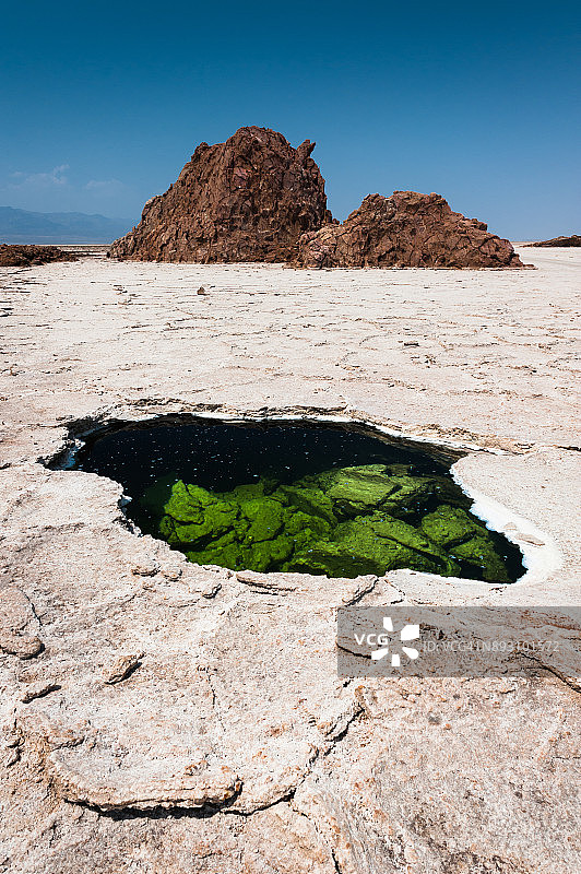 一个奇怪的，充满水的洞中间的盐滩和岩石的形成在他的背景。达纳吉尔凹地,埃塞俄比亚图片素材