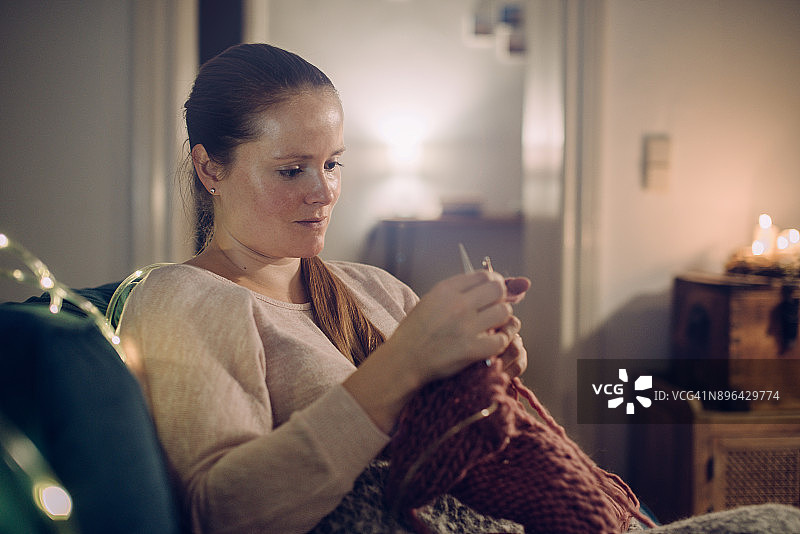 妇女在家里编织。图片素材