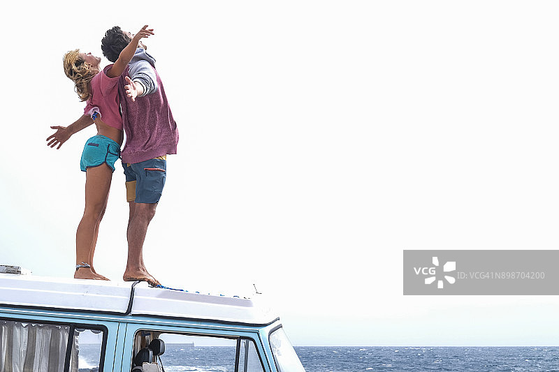 西班牙，特内里费，一对年轻夫妇站在车顶享受自由图片素材
