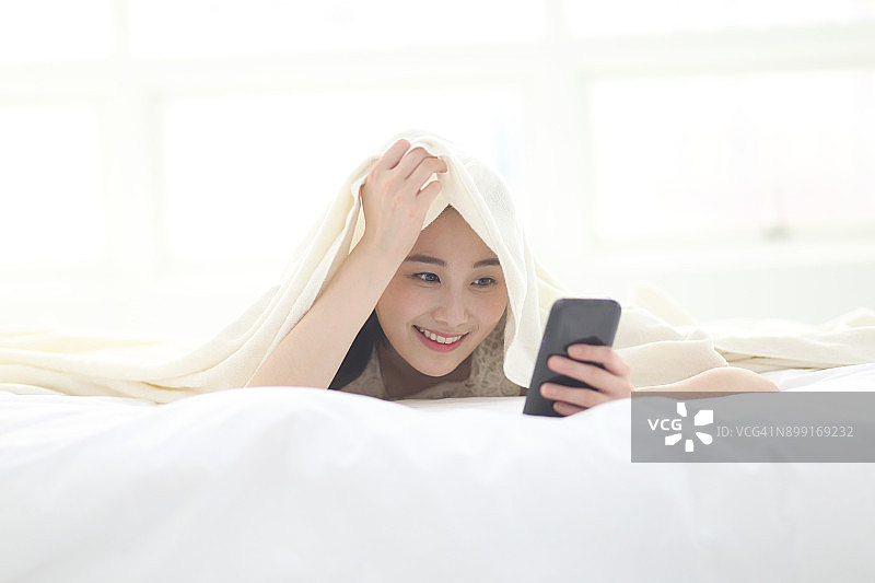女人在床上用手机图片素材