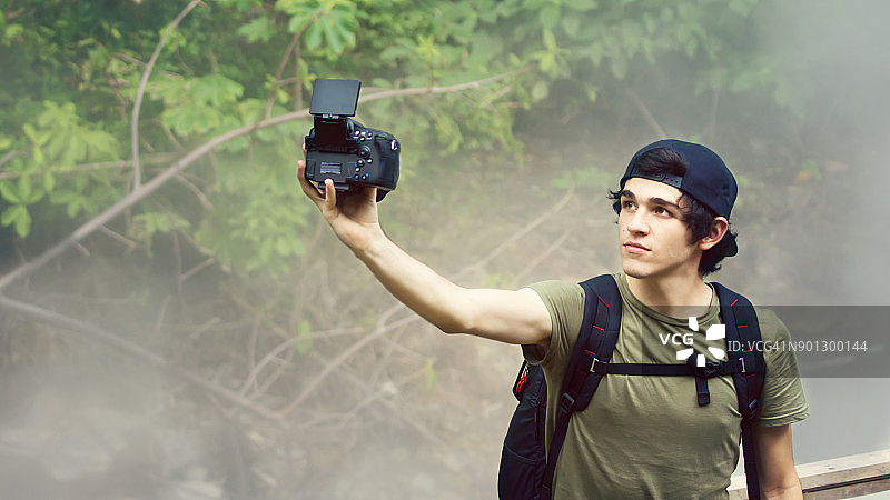 年轻人拿着相机自拍图片素材