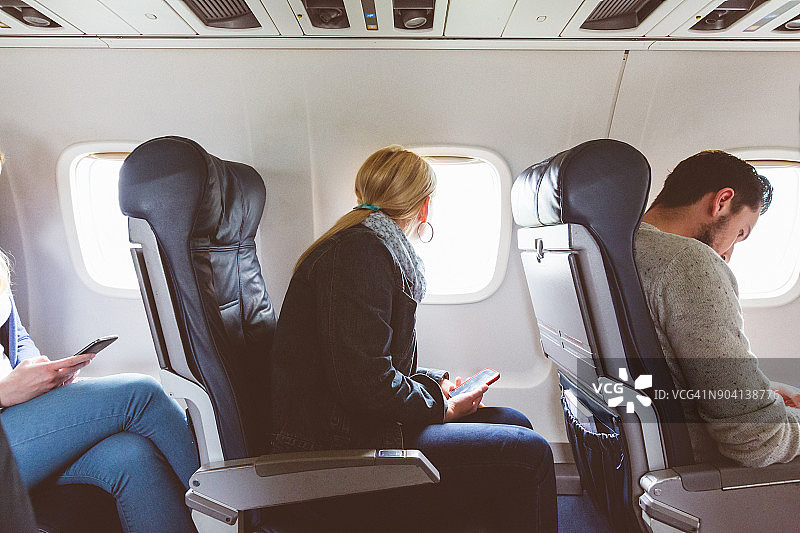 坐在飞机客舱靠窗的女人图片素材