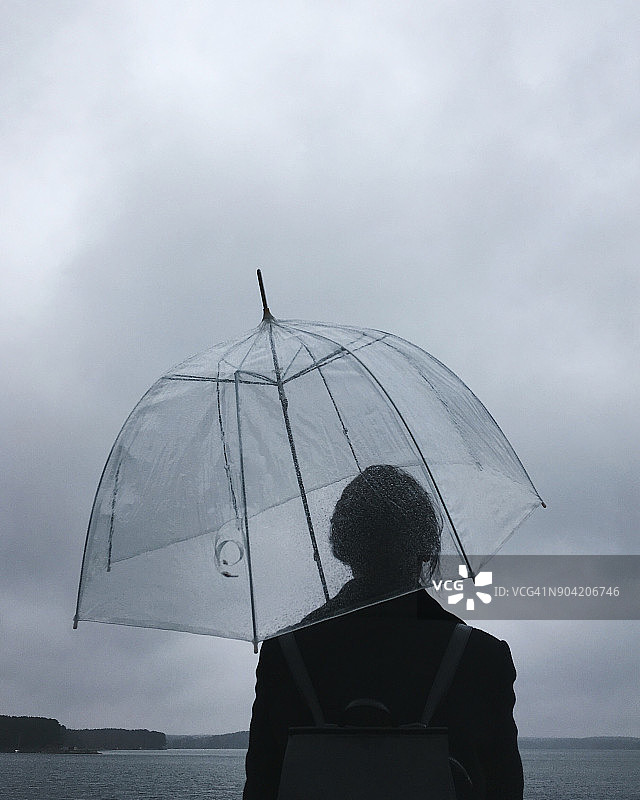 一个女人的后视图与伞的海边，明斯克，白俄罗斯图片素材