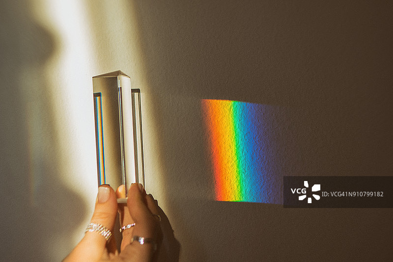 手握棱镜，反射彩虹图片素材