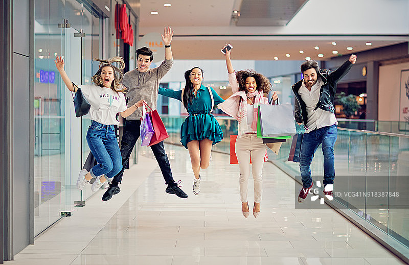 购物的朋友们在购物中心里蹦蹦跳跳图片素材