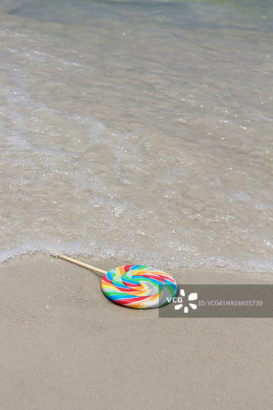 被遗弃在海滩上的彩色棒棒糖图片素材