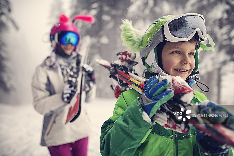 孩子们在一个美丽的冬日里扛着滑雪板图片素材