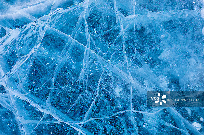 西伯利亚贝加尔湖冬季的冰面。蓝色背景的冰纹理图片素材