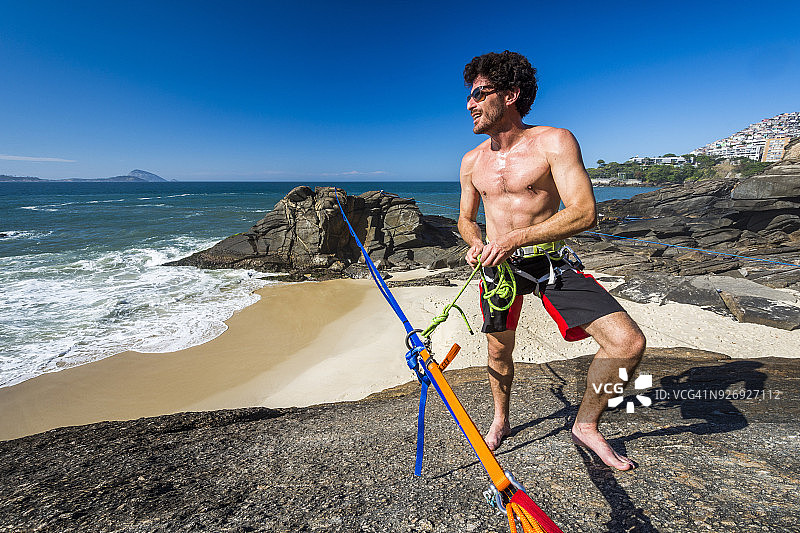 在巴西里约热内卢的雷伯伦海滩，一名男子正把自己绑在松弛的绳索上图片素材