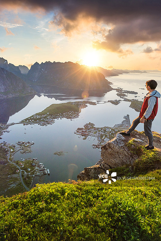 游客欣赏挪威罗浮敦群岛的夏日日落风景图片素材