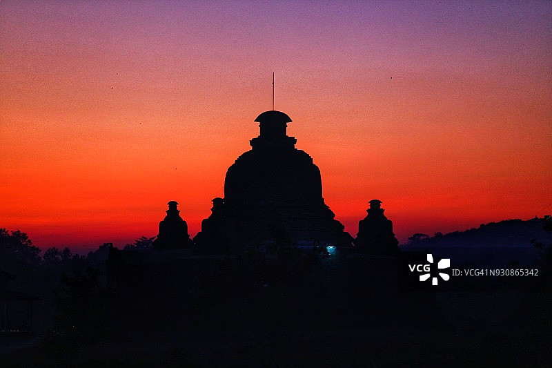日落戏剧性的蓝色，橙色，黄色，红色的天空和佛塔的剪影在缅甸若开邦图片素材