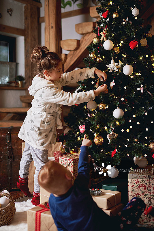 小女孩和男孩装饰圣诞树图片素材