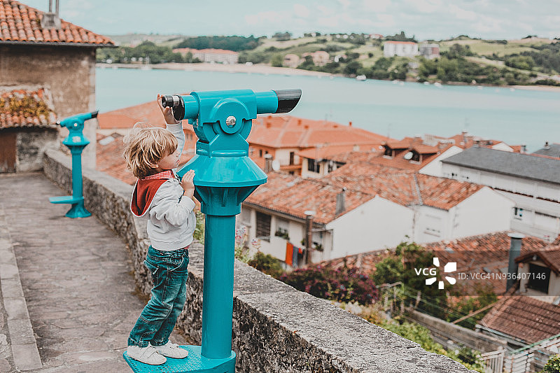 西班牙坎塔布里亚，一个男孩用双筒望远镜看风景图片素材