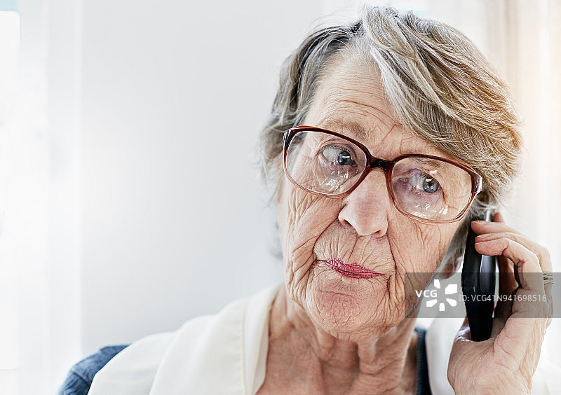 恼怒的老妇人听着手机短信图片素材