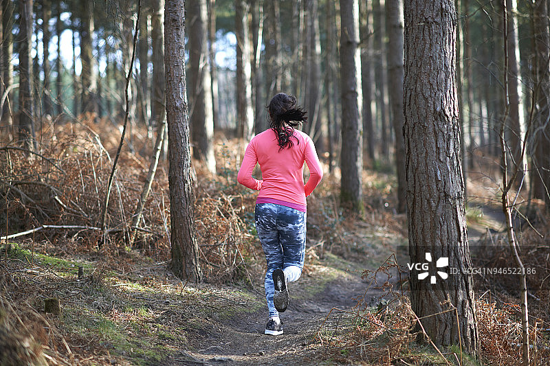 一个女人在树林里跑图片素材