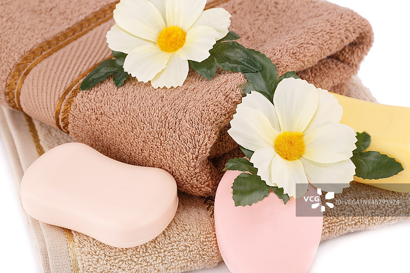 折叠的毛巾、肥皂和鲜花图片素材