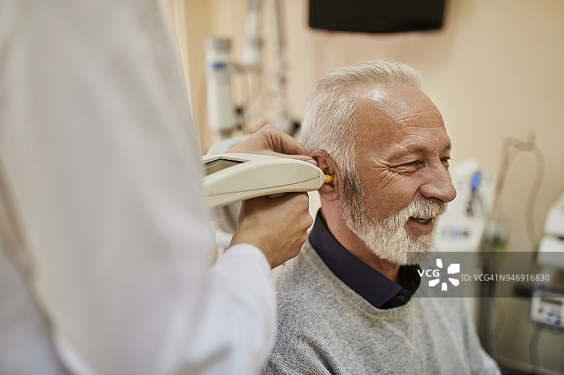 耳鼻喉科医生正在检查一位老人的耳朵图片素材
