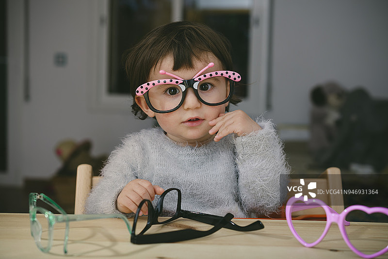 小女孩玩玩具眼镜的肖像图片素材