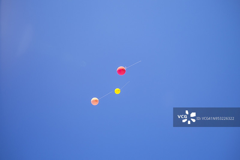 五颜六色的气球在蓝色的天空中飞走了。婚礼仪式。图片素材